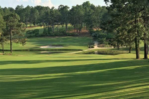 Golfer teeing off at Pinehurst Resort, minutes away from Vacation Pines lodging.