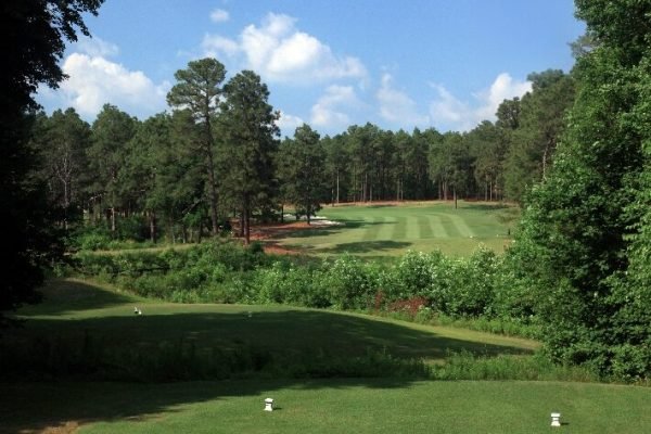 Golfer teeing off at Pinehurst Resort, minutes away from Vacation Pines lodging.