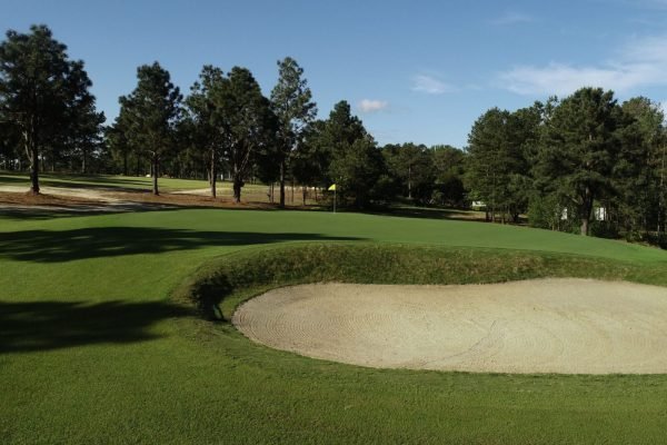 Golfer teeing off at Pinehurst Resort, minutes away from Vacation Pines lodging.
