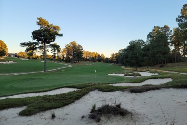 Golfer teeing off at Pinehurst Resort, minutes away from Vacation Pines lodging.