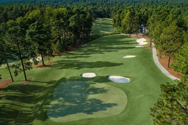 Golfer teeing off at Pinehurst Resort, minutes away from Vacation Pines lodging.