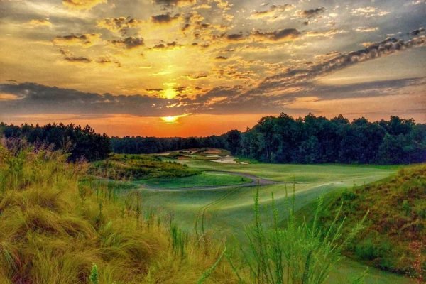 Golfer teeing off at Pinehurst Resort, minutes away from Vacation Pines lodging.