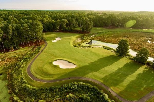 Golfer teeing off at Pinehurst Resort, minutes away from Vacation Pines lodging.